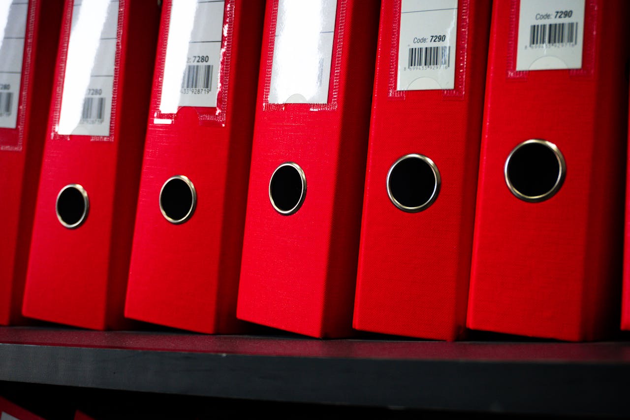 Close-up view of red office binders neatly organized on a shelf.